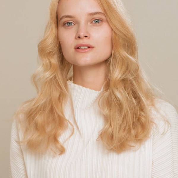 Model with long, healthy, wavy blonde hair looking directly at camera against a neutral background, Aveda Damage Remedy campaign by The Charles Group