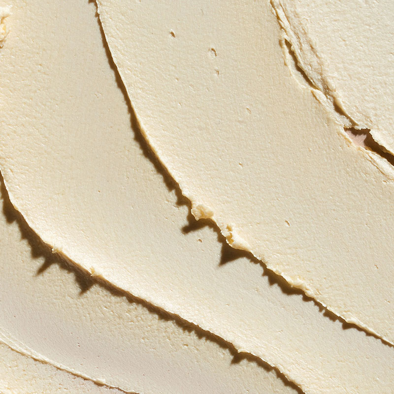 Extreme close-up of creamy mango butter texture, a key natural ingredient in Aveda Nutriplenish haircare