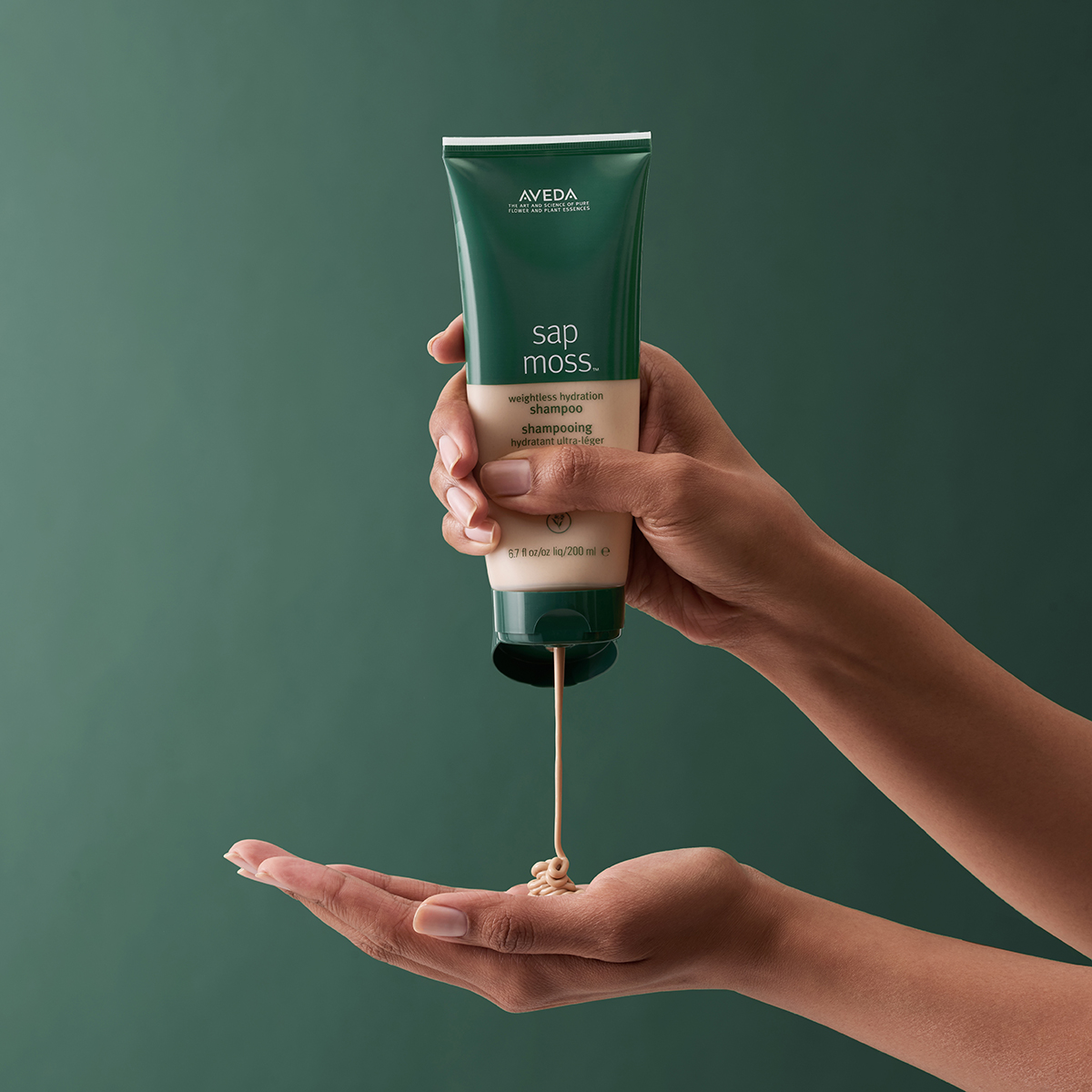 Aveda Sap Moss digital ad with product bottle on dark green textured background, designed by The Charles Group