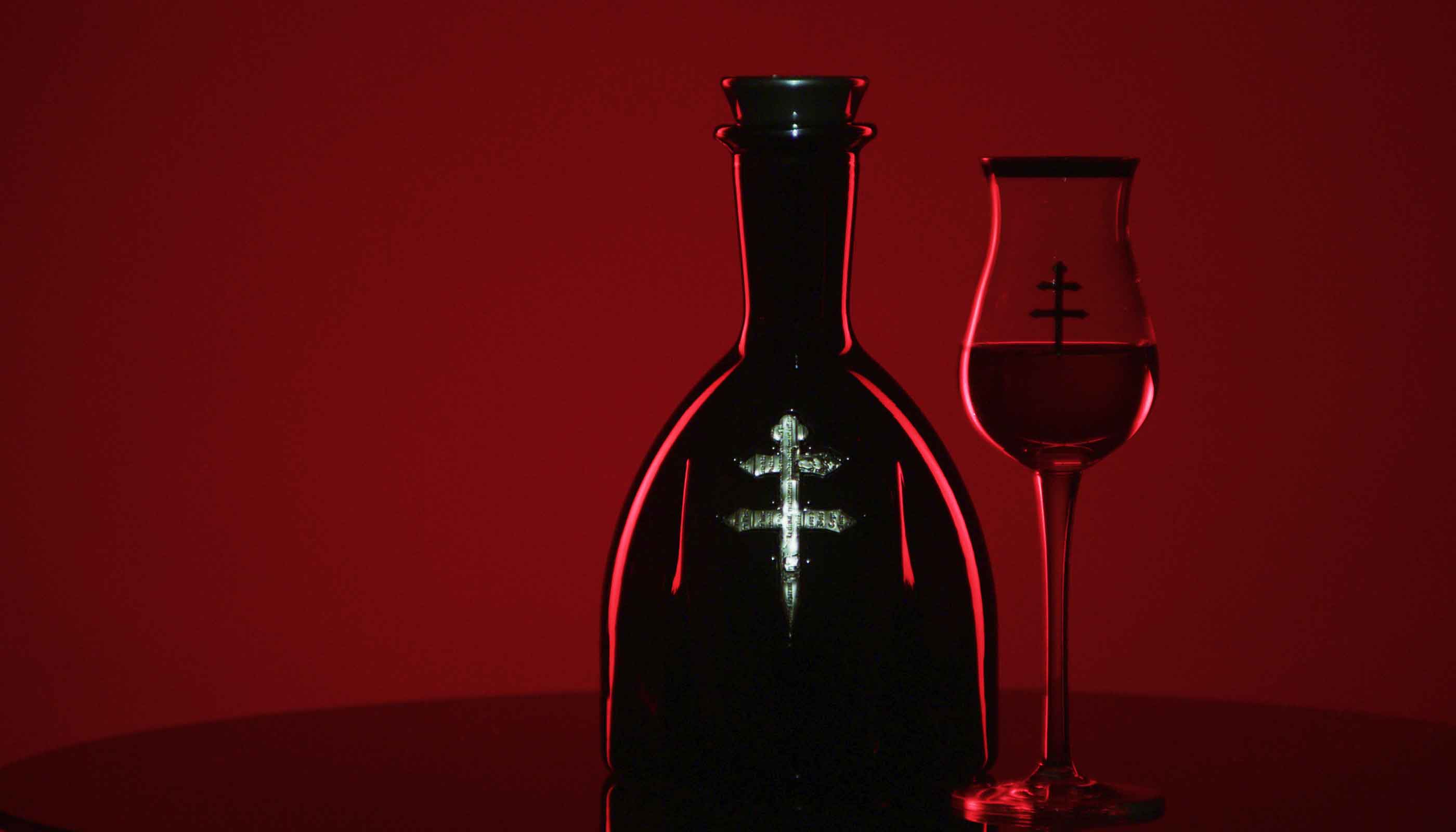 D'ussé cognac bottle and branded snifter glass dramatically lit against a deep red background, hero image for D'ussé Holiday campaign by The Charles Group