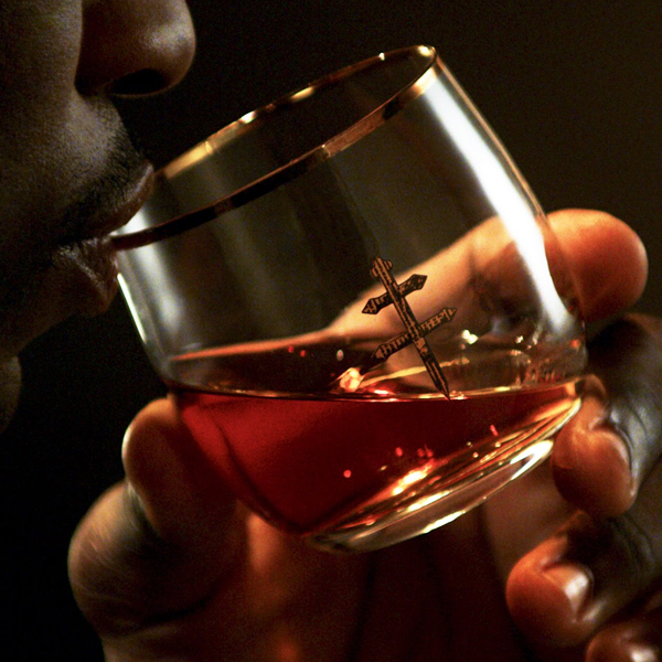 Close-up of a person sipping D'ussé cognac from a gold-rimmed branded glass, from the D'ussé Holiday social campaign by The Charles Group