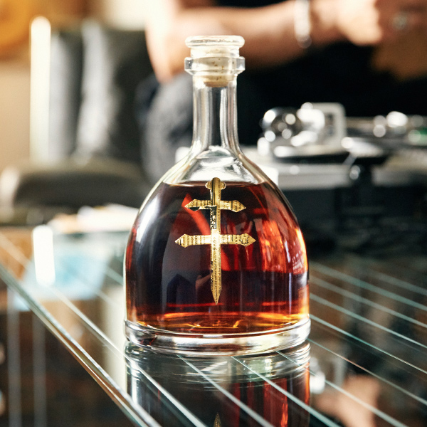 D'ussé VSOP cognac decanter on a glass table with a record player in the background, lifestyle content by The Charles Group
