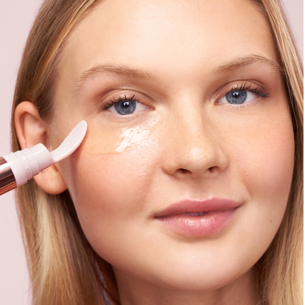 Model applying Erno Laszlo Multi-Task Eye Gel Cream under the eye with the pen applicator