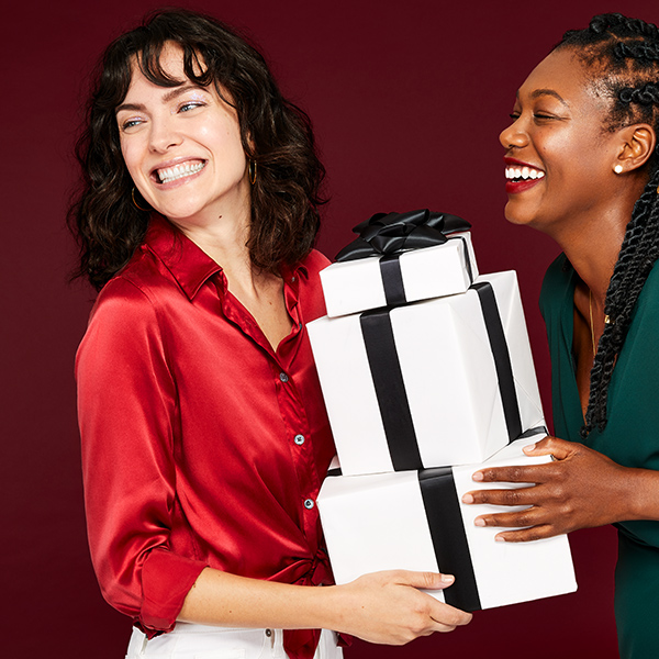 Two models sharing Erno Laszlo holiday gift boxes in seasonal campaign
