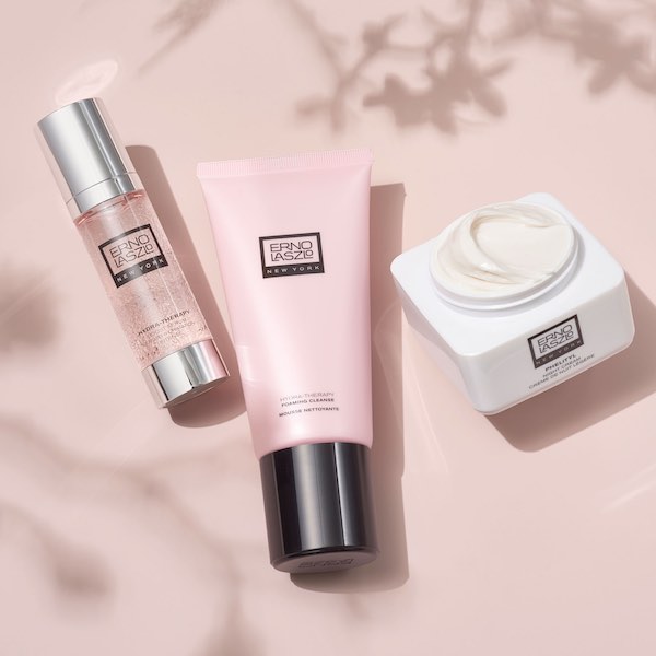 Erno Laszlo Hydra-Therapy serum, foaming cleanser, and cream arranged on pink background