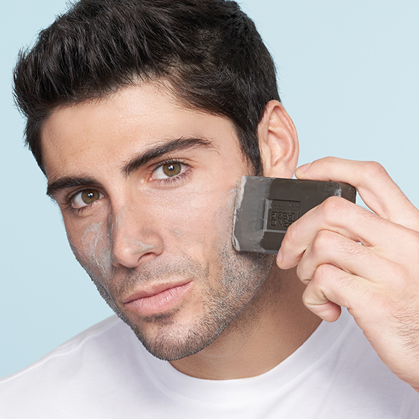 Man applying Erno Laszlo charcoal cleansing bar to face