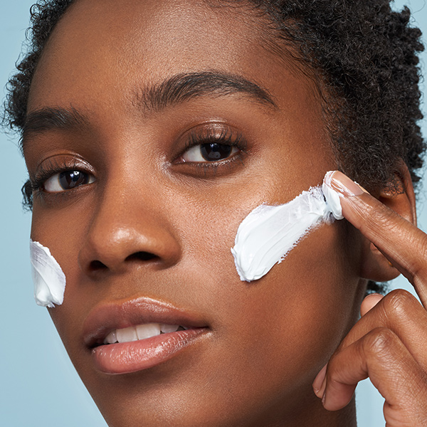 Model applying Erno Laszlo face cream in editorial beauty shot