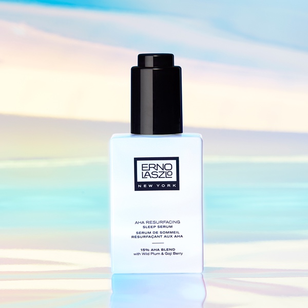 Single Erno Laszlo AHA Resurfacing Sleep Serum bottle centered against a soft iridescent background