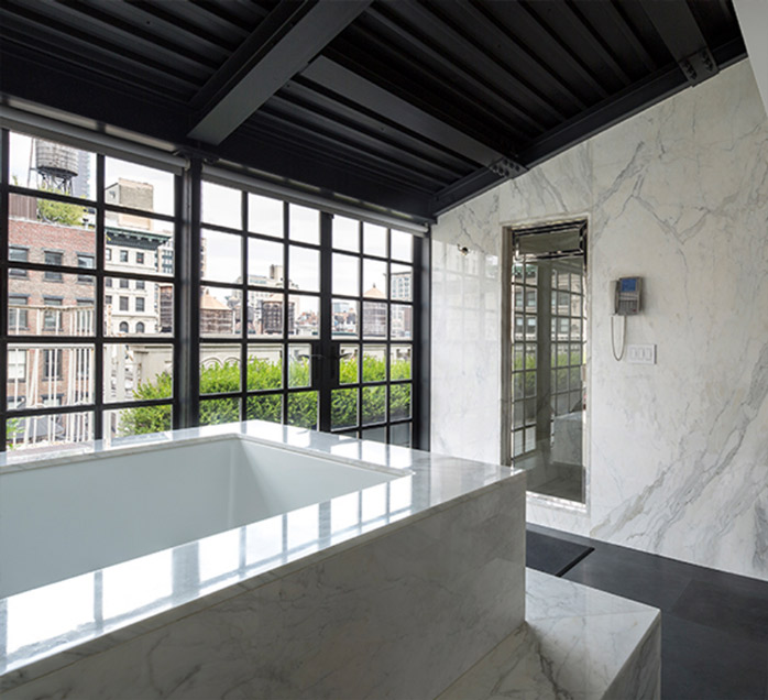 Luxury marble bathroom with floor-to-ceiling steel windows overlooking a New York City rooftop view