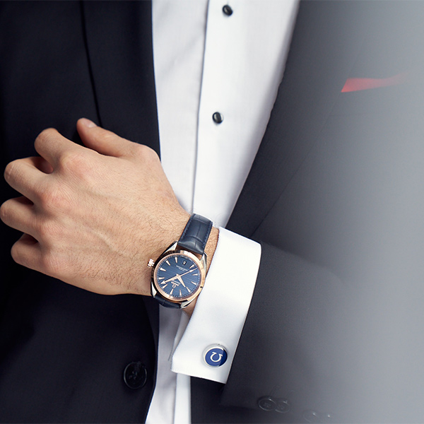 Woman relaxing in a stylish living room wearing an Omega watch, lifestyle content by The Charles Group