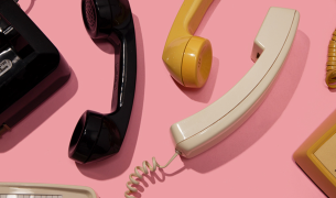 Flat lay of vintage telephone handsets in black, yellow, and cream on a pink background, used in HP brand content by The Charles Group
