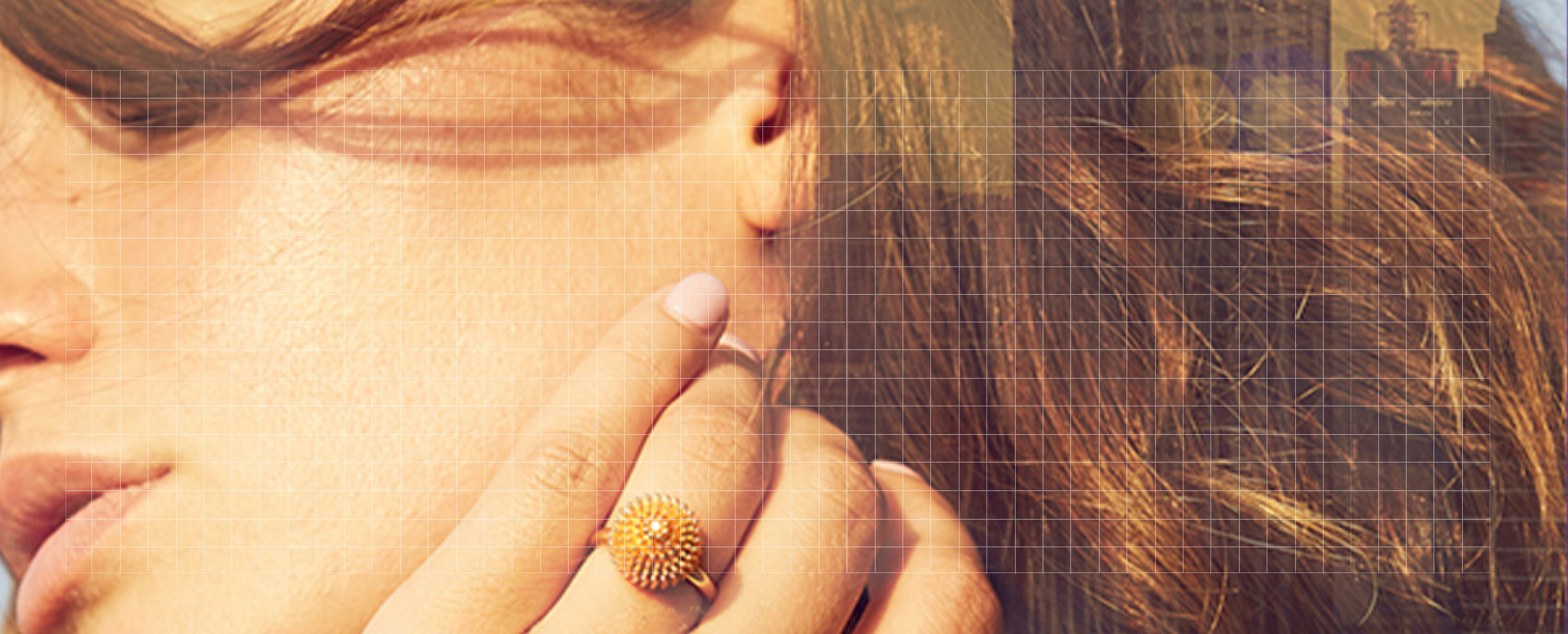 Close-up of a woman's hand with a gold Cartier ring resting against her cheek